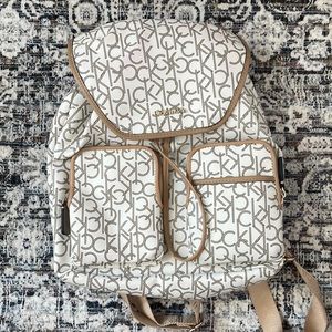 Calvin Klein backpack purse. Colors are white and tan with CK letter print.